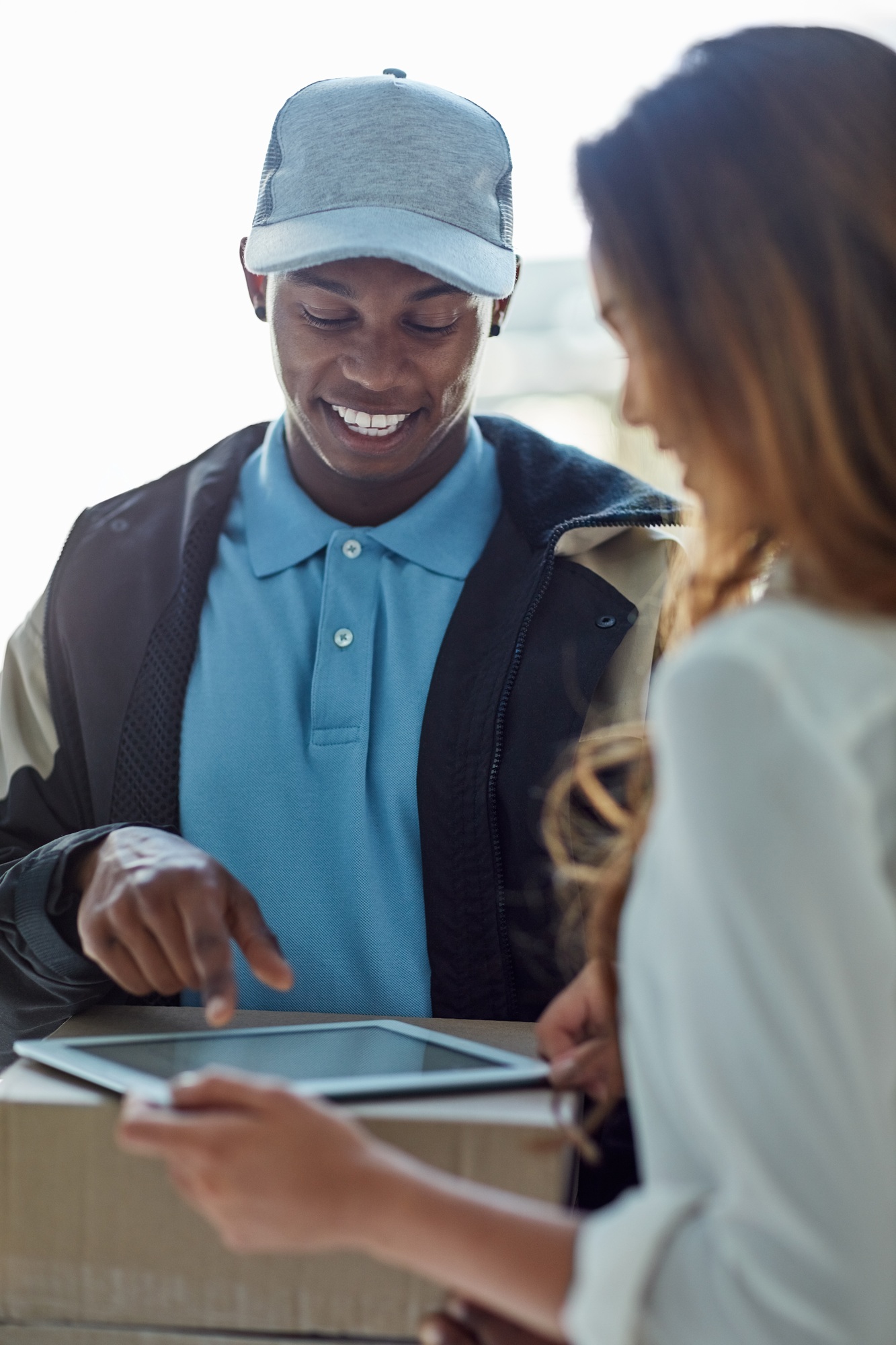 Cropped shot of a businesswoman using a tablet to sign for a package delivered to her office